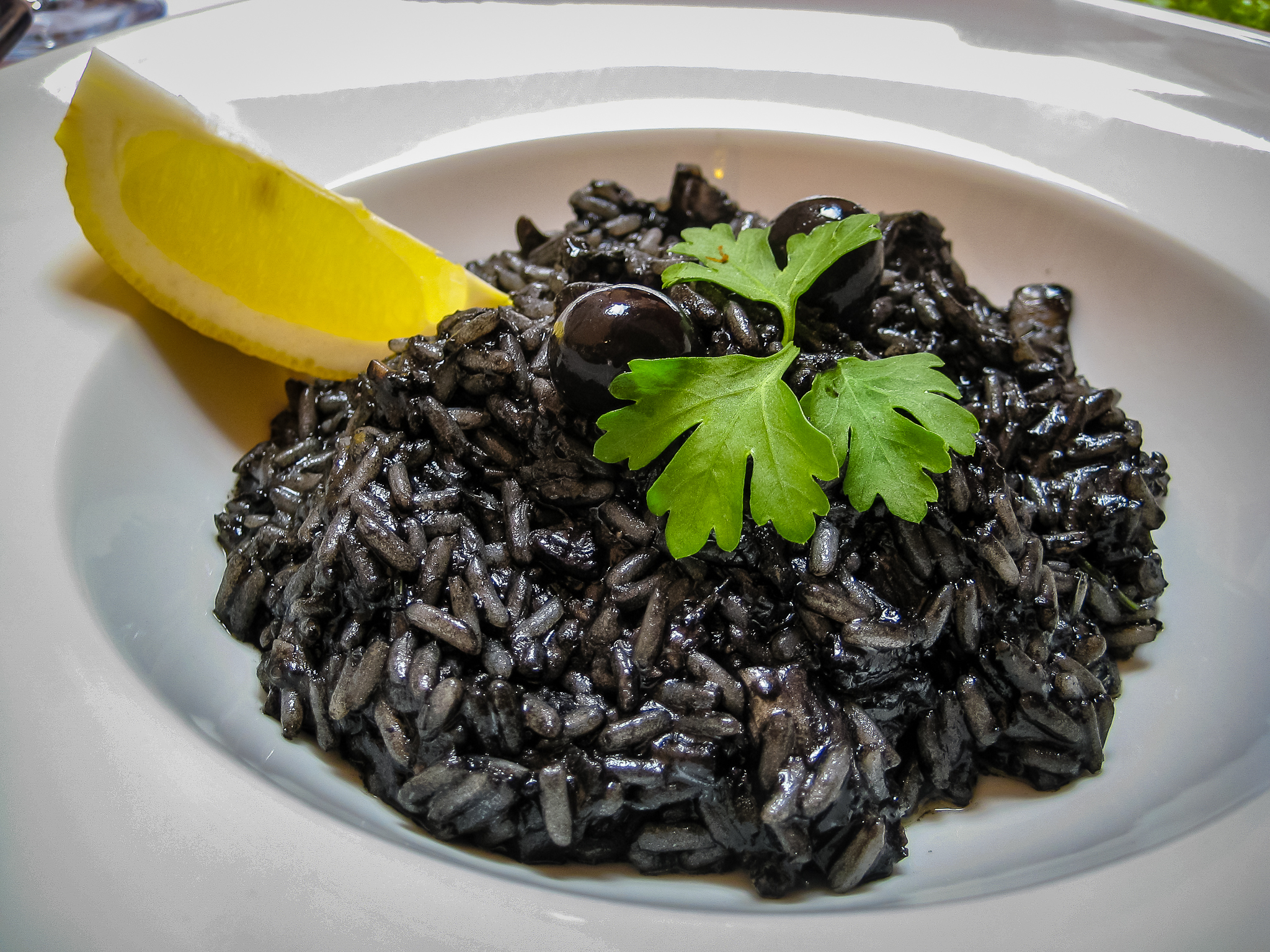 Black risotto (crni rižot) with lemon and parsley garnish
