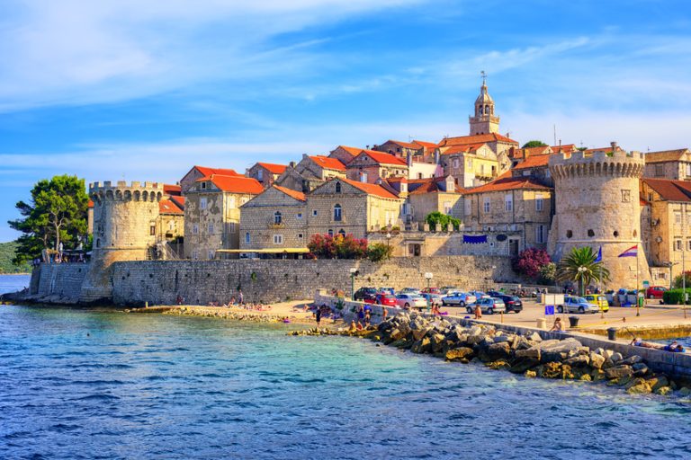 old town by the sea with colorful houses and a church tower, Korcula