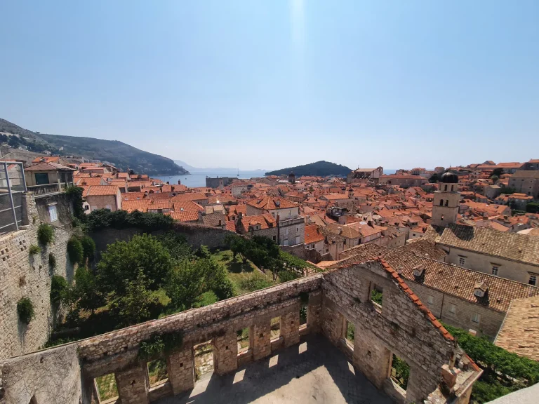 Panorama of Dubrovnik Old Town's terracotta rooftops and bell tower from the City Walls